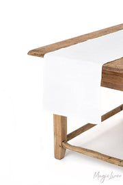 MagicLinen - Linen table runner on a wooden table, showcasing its soft texture and versatility for kitchen decor at Athens Cooks.