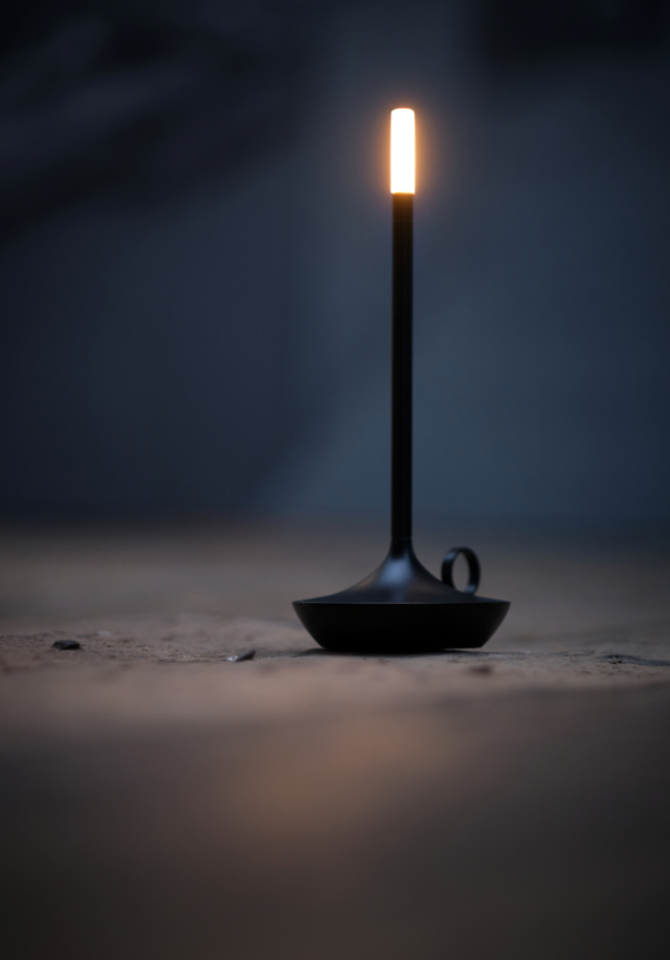 VANMOKUM | GRAYPANTS Wick Portable Rechargeable Lamp - Black, resembling a lit candle on a stand, perfect for creating ambiance in various settings.