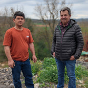 Two men stand in a rural setting, showcasing the Burlap & Barrel - Herbes de Provence - Single Origin Spice & Seasoning Blend: 0.8 oz glass jar.