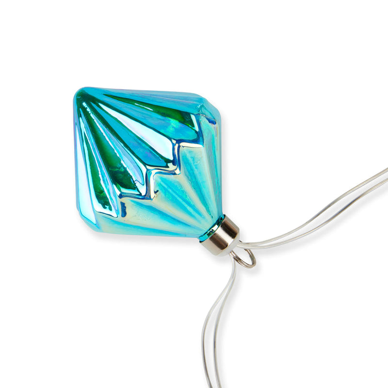 MoMA | LED String Lights Diamond featuring a single turquoise-blue, faceted bulb with a geometric pattern, hanging from a clear cord, ideal for versatile, elegant decor.