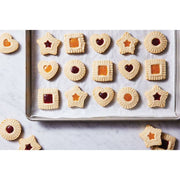 HIC - Harold Import Co. - King Arthur Thumbprint Cookie Cutters 4-Piece Set creating assorted jam-filled cookies on a baking sheet with embossed edges and center indents.