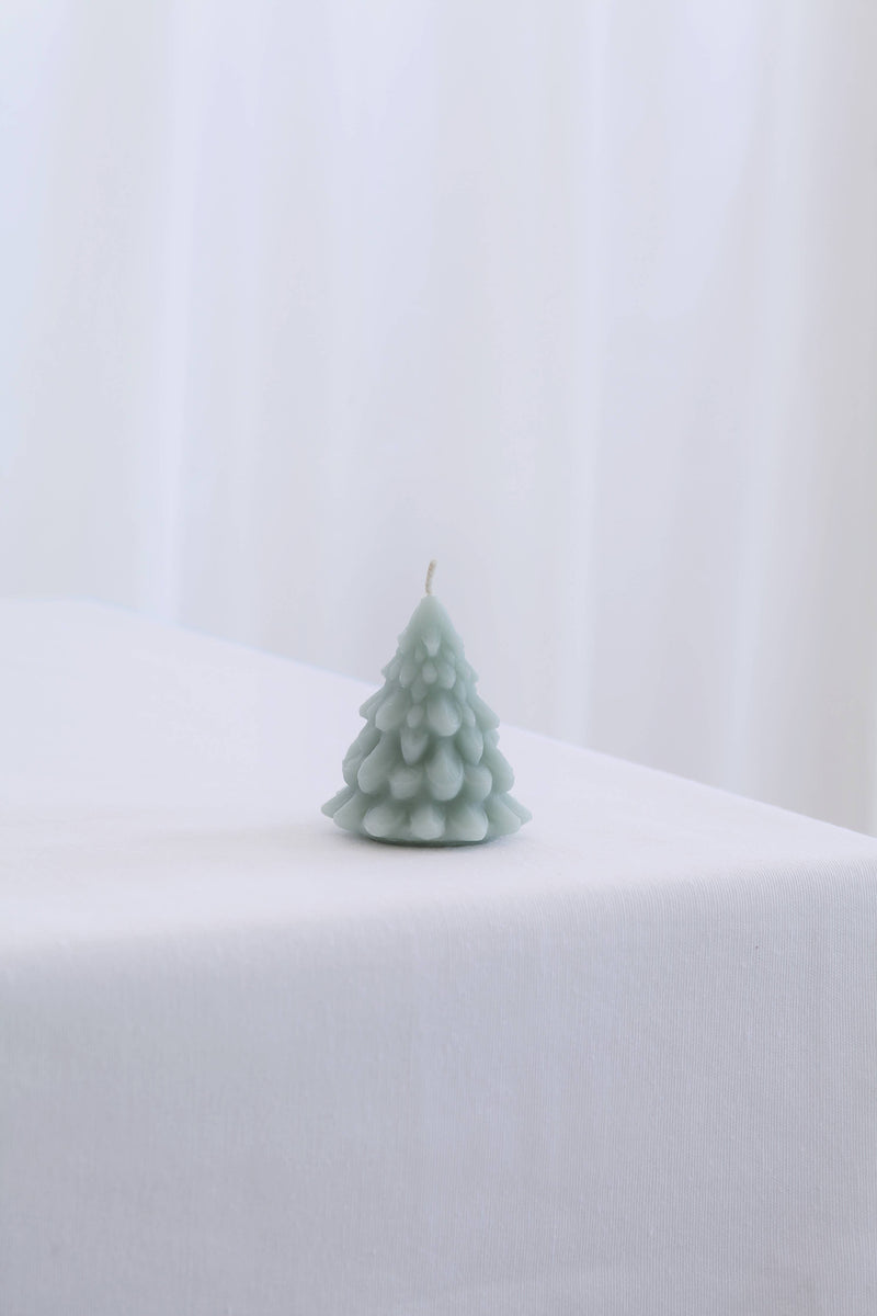 Mo&Co Home Exclusive: Sculpted Beeswax Tree candle, small size, hand-poured, pastel-green, fir tree shape, adding elegance to holiday settings.
