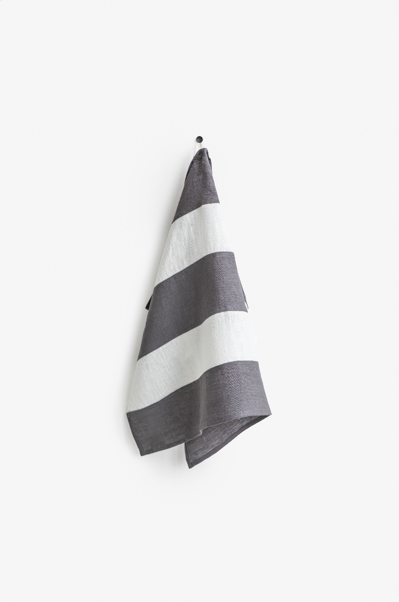 Striped linen tea towel hanging on a hook, featuring a loop for easy storage. Part of MagicLinen's zero-waste program, ideal for eco-friendly kitchens.