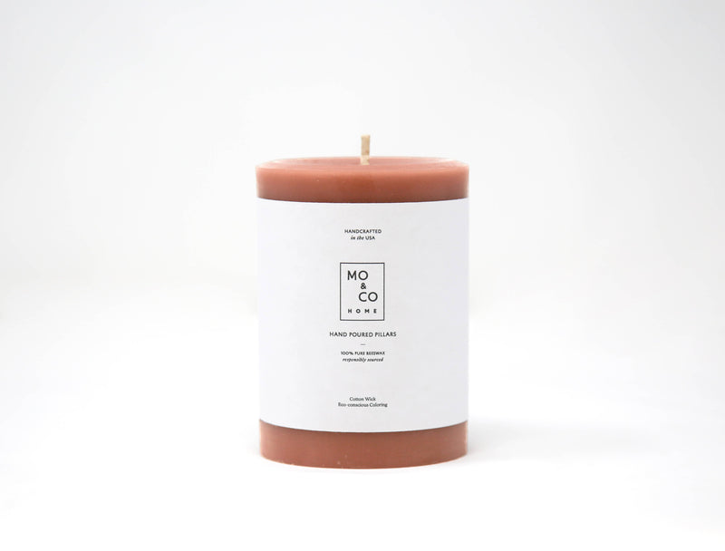 Mo&Co Home - 100% Beeswax Pillar Candle, Terra Cotta: 3x6 Inch, featuring a brown cylindrical shape with a white label, ideal for home decor.