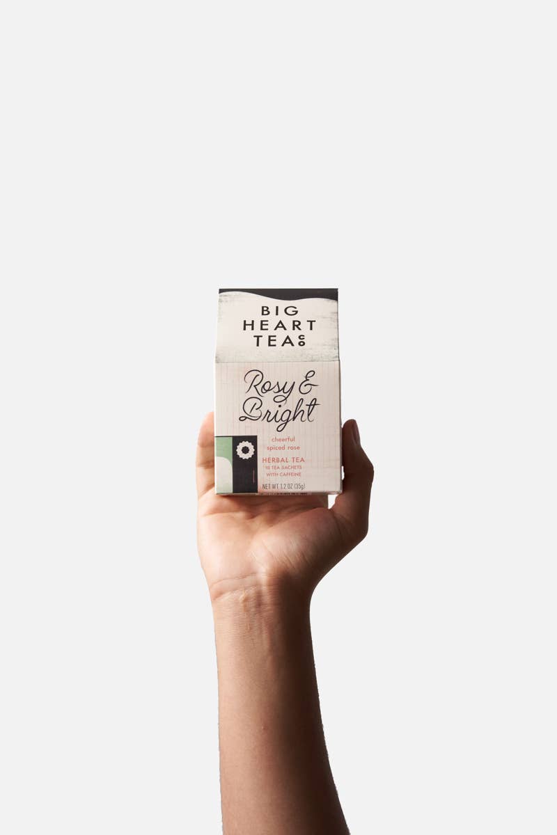 Big Heart Tea Co. - Rosy & Bright 10 ct Tea Bags, held in hand, showcasing spiced rose herbal blend with recyclable packaging, ideal for holiday brewing.