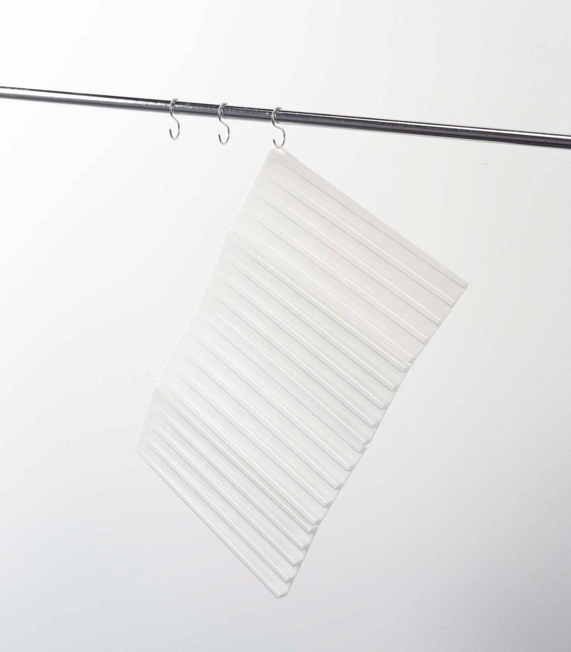 Yamazaki Home - Tower Folding Dish Drainer Mat hangs on a metal rod, showing its compact, foldable design ideal for organized kitchen spaces.