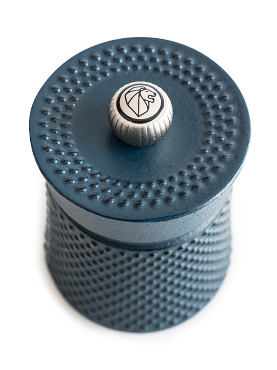 Peugeot | Bali Cast Iron Pepper Mill, featuring a textured grip and diamond-knurled pattern, crowned with a lion head logo, perfect for culinary precision.