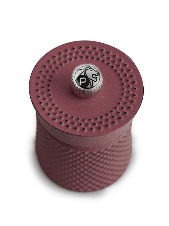 Peugeot | Bali Cast Iron Pepper Mill, Red, featuring a compact cylindrical design with a raised diamond texture for grip, perfect for enhancing your kitchen's elegance.