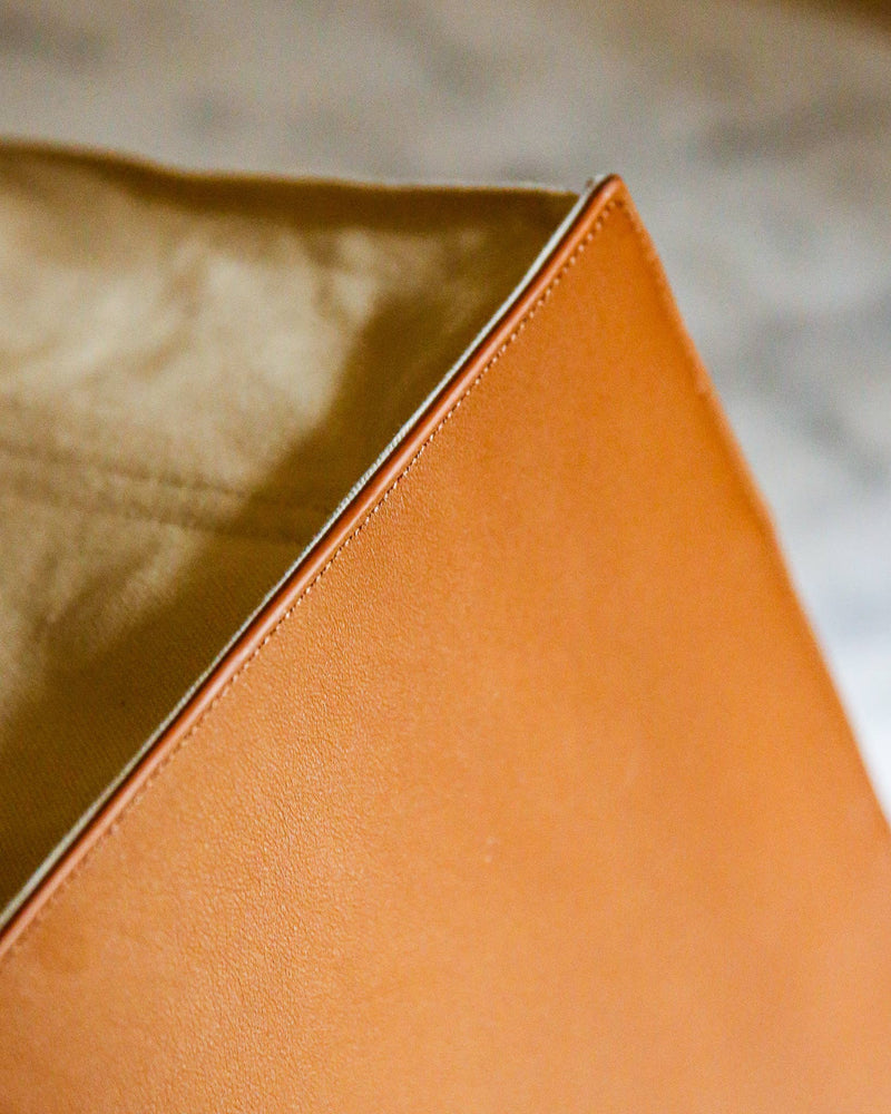 Close-up of the CapaBunga® Deluxe Canvas Market Tote's corner, featuring burnt-orange leather exterior and beige fabric lining, highlighting premium craftsmanship and eco-friendly design.