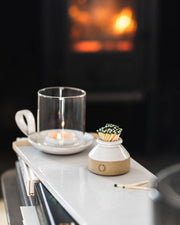 Farmhouse Pottery - Milk Bottle Match Striker with green-tipped matches beside a lit tealight, enhancing candle displays. Includes matches; crafted in Vermont stoneware.