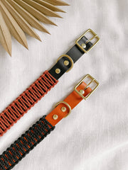 EMBER & IVORY - Black/Rust WIDE Leather & Macrame Collar: Small, features leather and rust-red macramé with brass hardware, displayed on a fabric background with a decorative leaf.