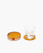 Graf Lantz - Kobon Leather Round Tray - Natural, elegantly holds a glass of water with ice, showcasing its versatility as a stylish organizer.