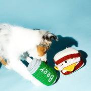 Puppy engages with Ware of the Dog Hand Knit Beer Dog Toy, made from fair-trade lambswool using natural dyes, offering a playful, ethical pet accessory.