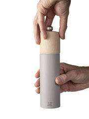 Peugeot | Boreal Salt + Pepper Mills - Sage Green Salt Mill, featuring a wooden top and metal body, held by hands demonstrating the grinding mechanism.