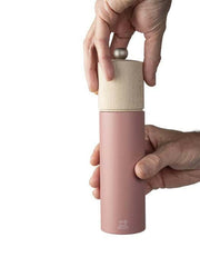 Peugeot | Boreal Salt + Pepper Mills - Sage Green Salt Mill, featuring a wooden top being removed from the sleek pink cylindrical body for refilling.