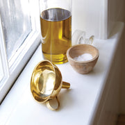 Sir|Madam | Brass Funnel displayed with olive oil bottle and salt cellar on a windowsill, highlighting its essential role in a well-equipped kitchen.