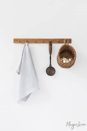 Linen tea towel on a kitchen rack with utensils, showcasing its durability and absorbency, ideal for cleaning tasks. MagicLinen - Linen Tea Towels, available at Athens Cooks.