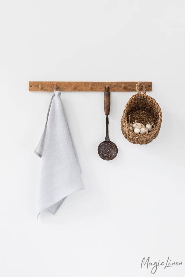 Linen tea towel on a kitchen rack with utensils, showcasing its durability and absorbency, ideal for cleaning tasks. MagicLinen - Linen Tea Towels, available at Athens Cooks.