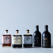 Mikuni Wild Harvest USA - Haku Smoked Shoyu, 375 ml glass bottle, showcased among liquor bottles with distinct craftsmanship and unique flavor from Kyoto.