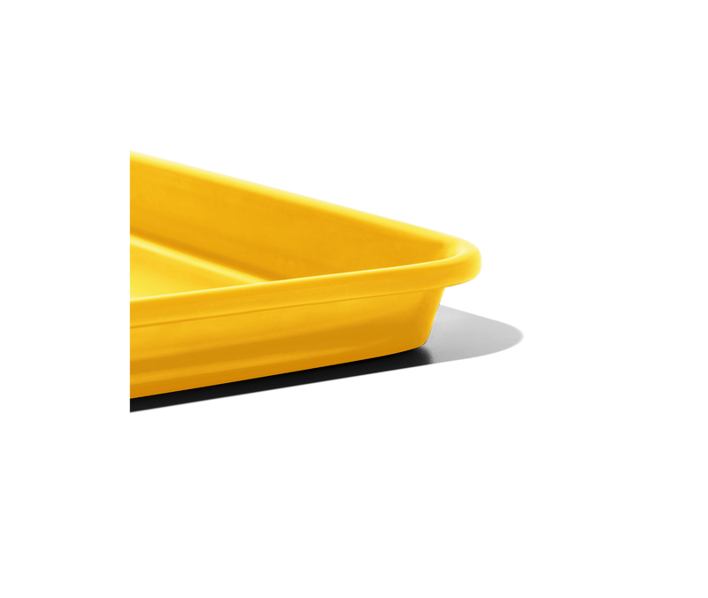 Great Jones | Little Sheet - Pepper, a compact, oven-safe yellow tray with nonstick coating, ideal for baking or reheating, showcased against a black backdrop.