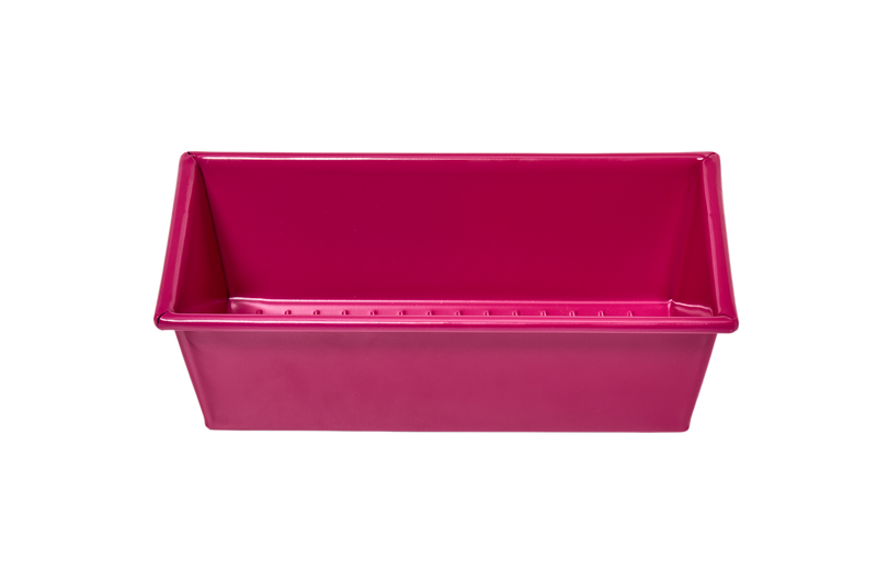 Great Jones | Breadwinner - Raspberry: A pink 1-lb loaf pan with a wavy, corrugated surface for nonstick baking, oven-safe and dishwasher-friendly.