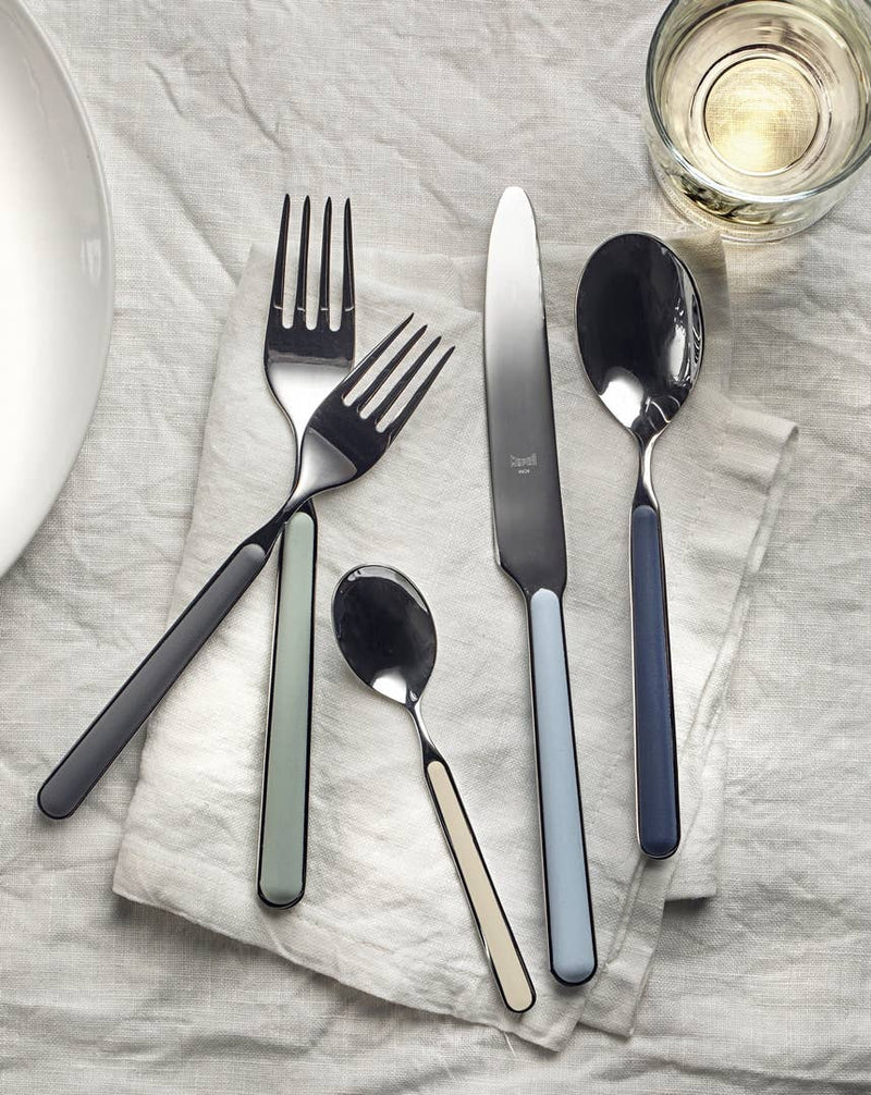 Mepra SPA - PLACE SET 5 PCS FANTASIA SUNFLOWER: Grey silverware set, including fork, spoon, and knife, displayed elegantly on a napkin. Made from durable 18/10 stainless steel and resin.