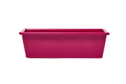 Great Jones | Breadwinner - Raspberry, a pink loaf pan with a wavy, nonstick bottom, ideal for baking.