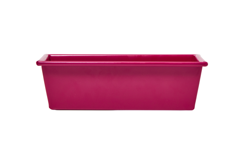 Great Jones | Breadwinner - Raspberry, a pink loaf pan with a wavy, nonstick bottom, ideal for baking.
