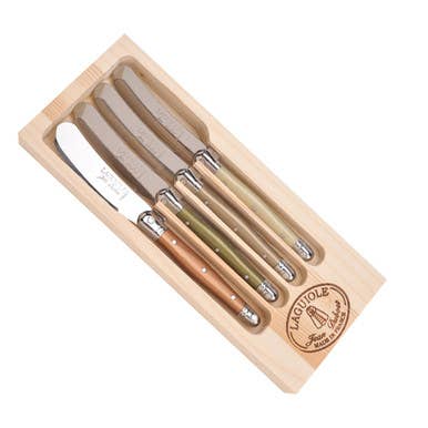 The French Farm - Jean Dubost 4 Mineral Colored Spreaders in a branded wooden box, featuring short stainless blades and muted wooden handles, ideal for serving cheeses.