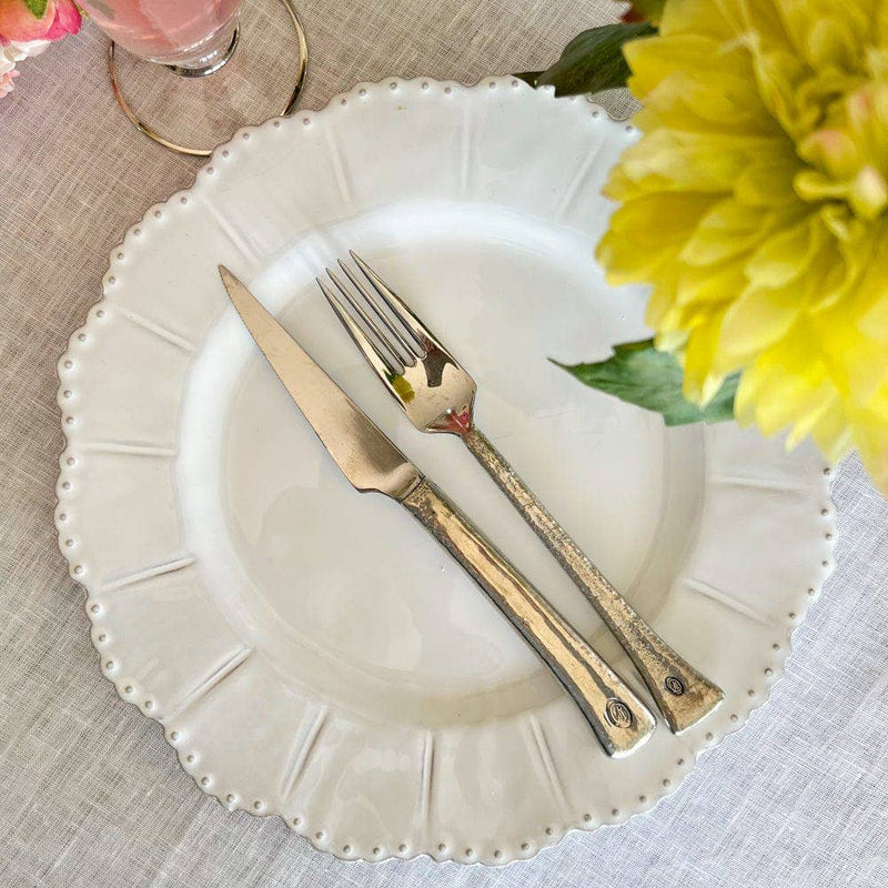 Bella Bianca Beaded Dinner Plate with fork and knife, showcasing Italian stoneware's durability and elegance. Ideal for enhancing table art, available at Athens Cooks.