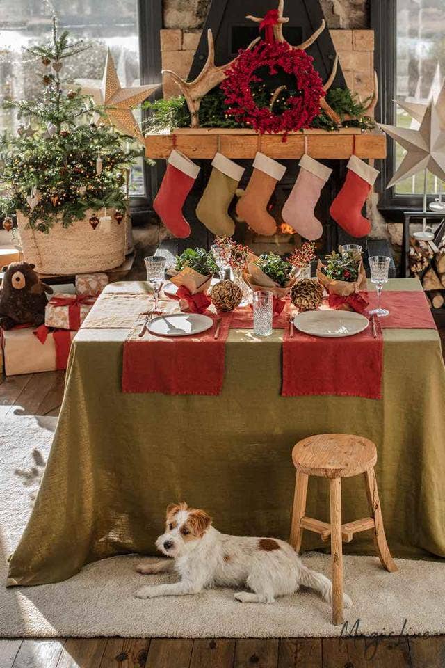 MagicLinen - Embroidered Christmas Stockings hang on a mantel, showcasing a cozy, rustic holiday scene with personalized, handcrafted linen stockings.
