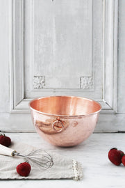 Coppermill Kitchen LLC - Coppermill Vintage Inspired Mixing Bowl with handle, set on marble, accompanied by a whisk and strawberries, embodying elegance and warmth in cooking.