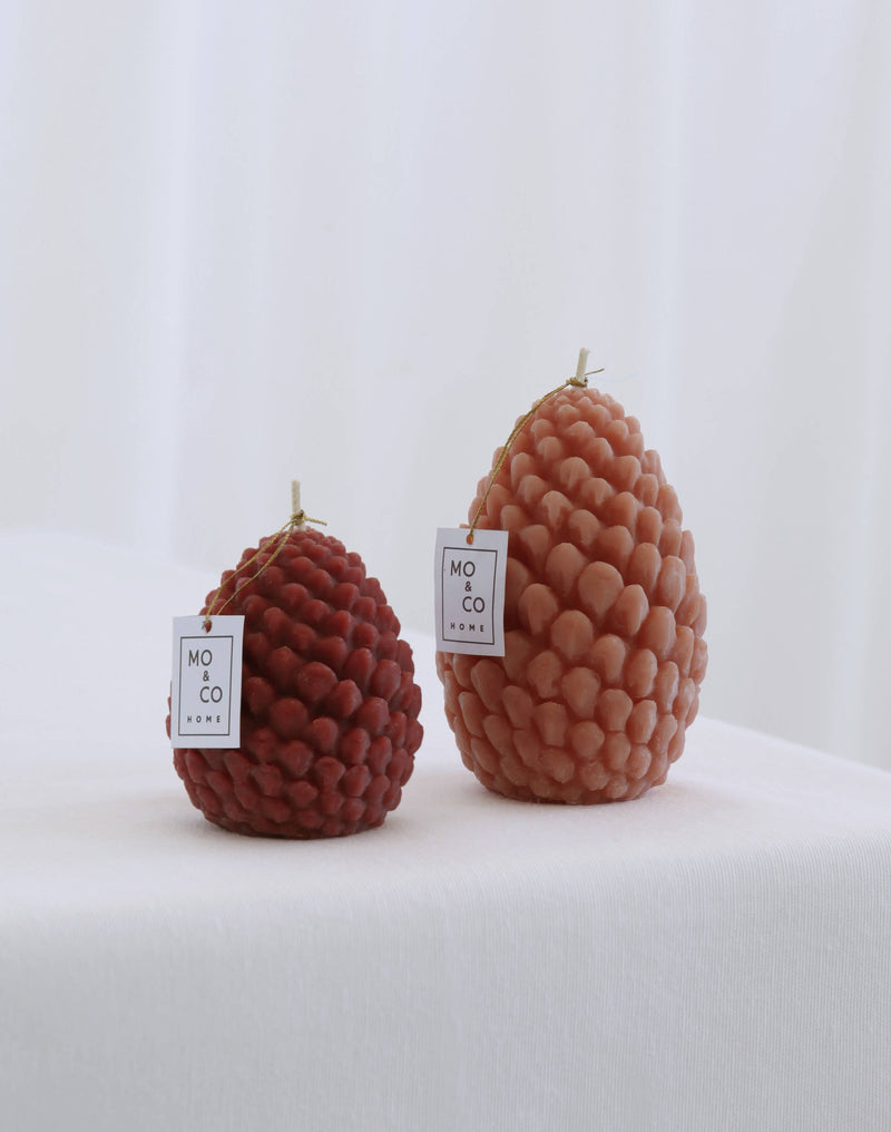 Mo&Co Home Exclusive: Sculpted Beeswax Pine Cones, featuring two hand-poured candles in pine-cone shapes, showcasing refined artistry in two distinct sizes for elegant holiday decor.