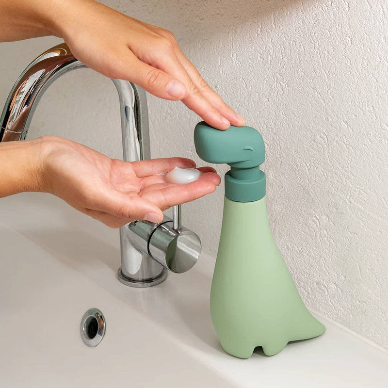 OTOTO - Soapasaurus hand soap dispenser in use at a sink, adding fun to handwashing with its unique dinosaur design.