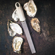 Microplane | Premium Zester, Grater - Classic Blue beside freshly-shucked oysters, showcasing its precision design for zesting and grating, ideal for culinary enthusiasts.