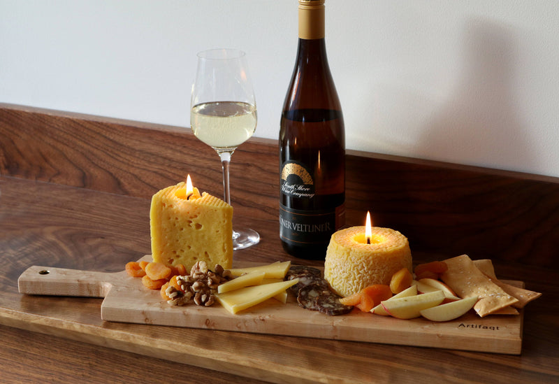 Blue Cheese Beeswax Candle molded from Birchrun Hills Blue Cheese, placed on a table with wine and cheese, highlighting its artisanal craftsmanship and eco-conscious materials.