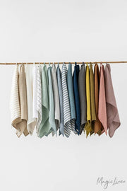 Linen tea towels on a hanger, showcasing a variety of textures. Durable and absorbent, perfect for kitchen use. Made from European flax, featuring a hanging loop.