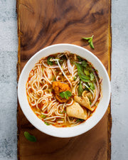 Tsuki Spicy Crab Miso Ramen Base, featured in a fragrant, chili-spiced noodle soup with herbs and tofu, perfect for creative home chefs seeking authentic flavors.