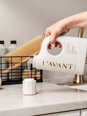 L’AVANT Collective - Laundry Detergent Fresh Linen being poured into a dosing cup, highlighting its eco-friendly, enzyme-driven formula for effective, gentle fabric care.