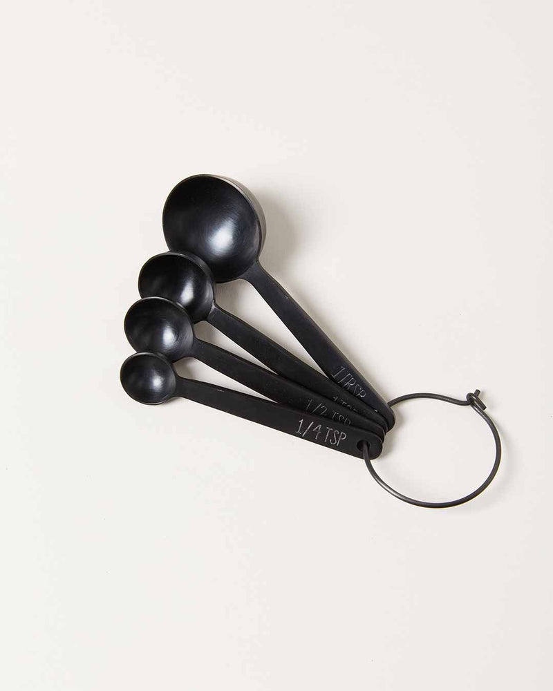 Farmhouse Pottery - Stowe Measuring Spoons: Brushed Gold / Single. Set of four black stainless steel spoons on a metal ring, offering precision and style for baking.