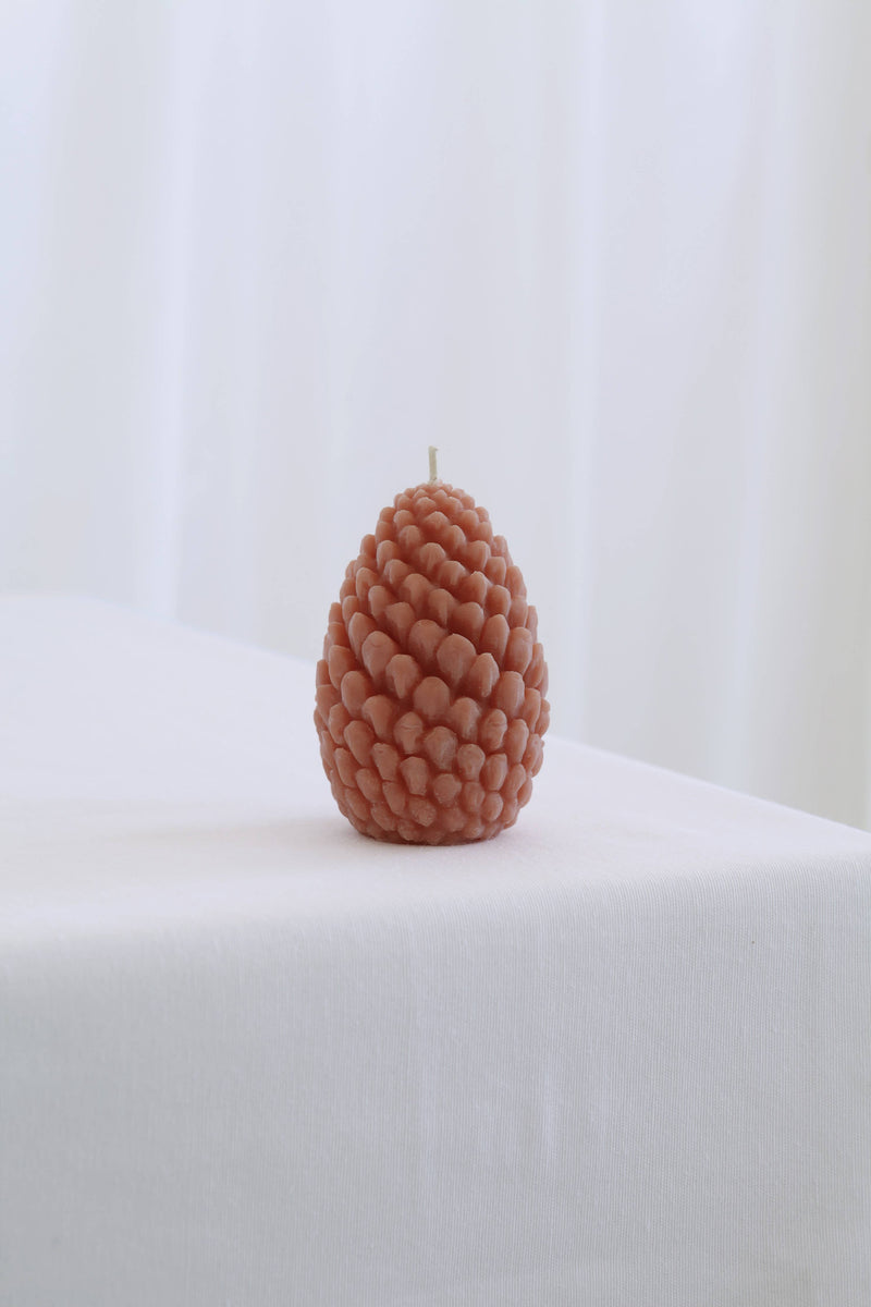 Mo&Co Home Exclusive: Sculpted Beeswax Pine Cone candle, resembling natural scales, sits upright, showcasing artisan craftsmanship in two sizes: Large 4 x 2 3/4.