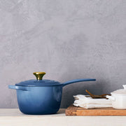 Le Creuset | Signature Saucepan with a handle displayed on a wooden surface, showcasing its durable design and functionality for versatile cooking.