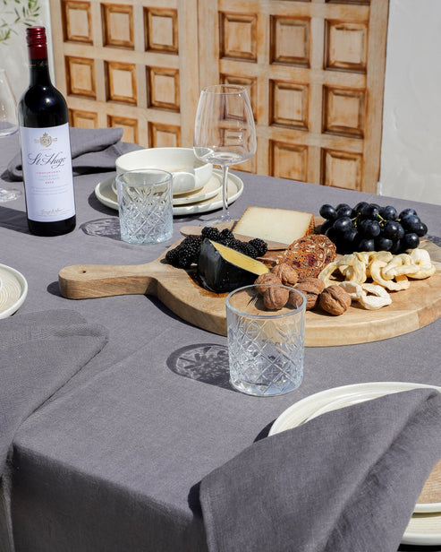 MagicLinen forest green linen tablecloth, 59 x 98 inches, with simple seam finish, perfect for versatile dining settings.