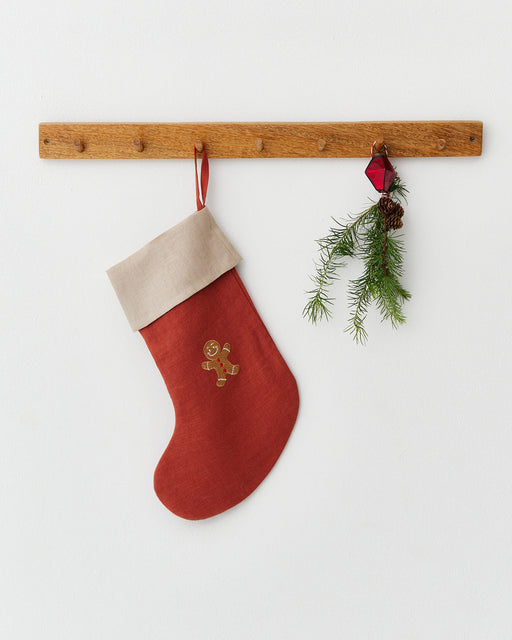 MagicLinen | Gingerbread Man Embroidered Christmas Stocking hangs on a peg rail, showcasing sustainable craftsmanship with pine sprig and ornament enhancing the festive decor.
