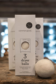 Common Good | Dryer Balls, Box Set of 3 on a wooden surface, showcasing an eco-friendly, natural laundry alternative from Athens Cooks.