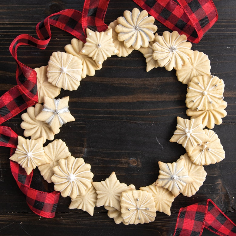 Nordic Ware | Pretty Pleated Cookie Stamps arranged in a wreath with cookies, showcasing star, diamond, and floral designs, ideal for holiday and year-round baking.