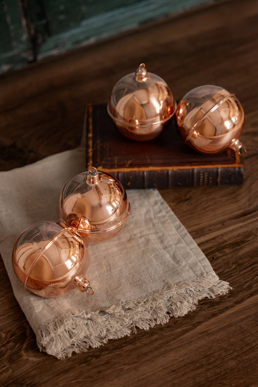 Coppermill Kitchen LLC | Vintage Inspired Ball Ornament on linen cloth with book, showcasing elegant, handcrafted design suitable for classic holiday decor, from Athens Cooks.