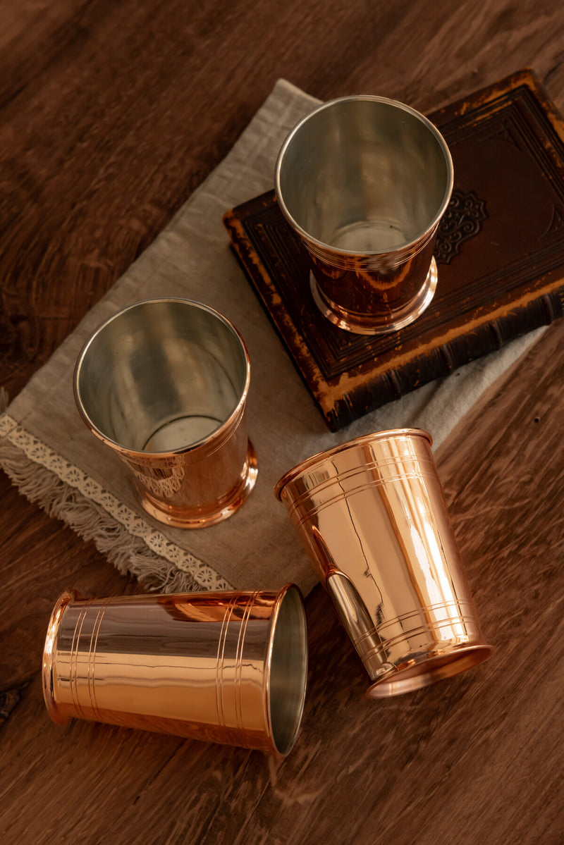 Coppermill Kitchen | Vintage Inspired Cocktail Tumbler set of four, elegantly arranged on wood, showcasing timeless Art Deco style and craftsmanship.