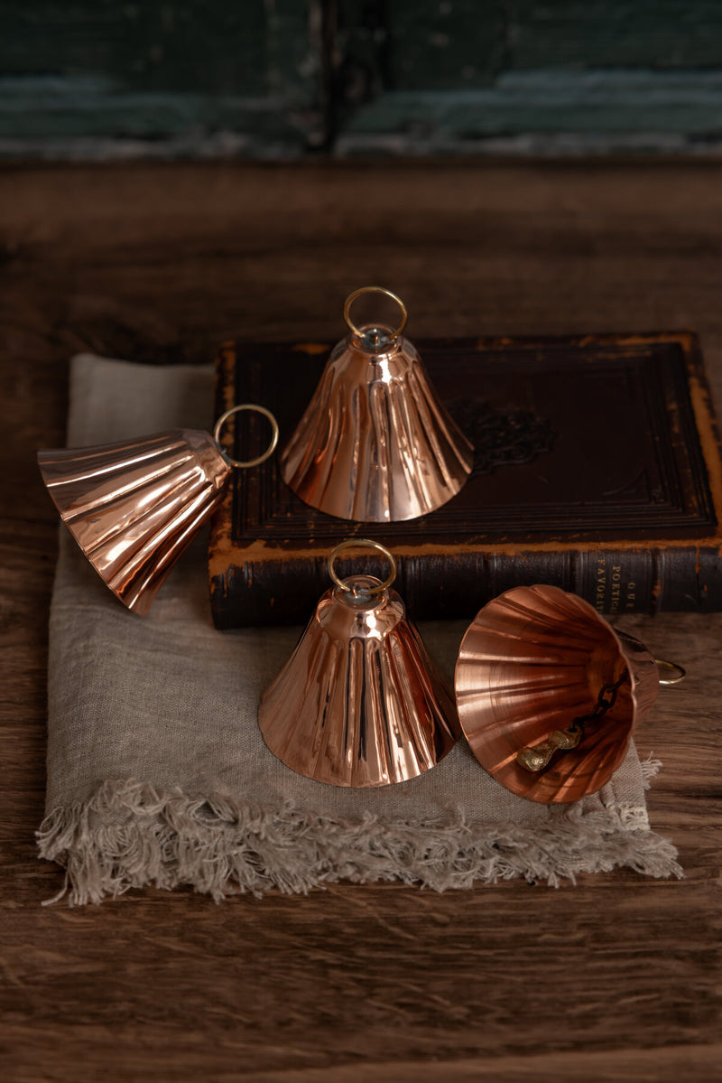 Coppermill Kitchen LLC | CMK Copper Bell Ornaments (Set of 2 or 4) on a linen cloth, showcasing vintage charm with handcrafted brass clappers.