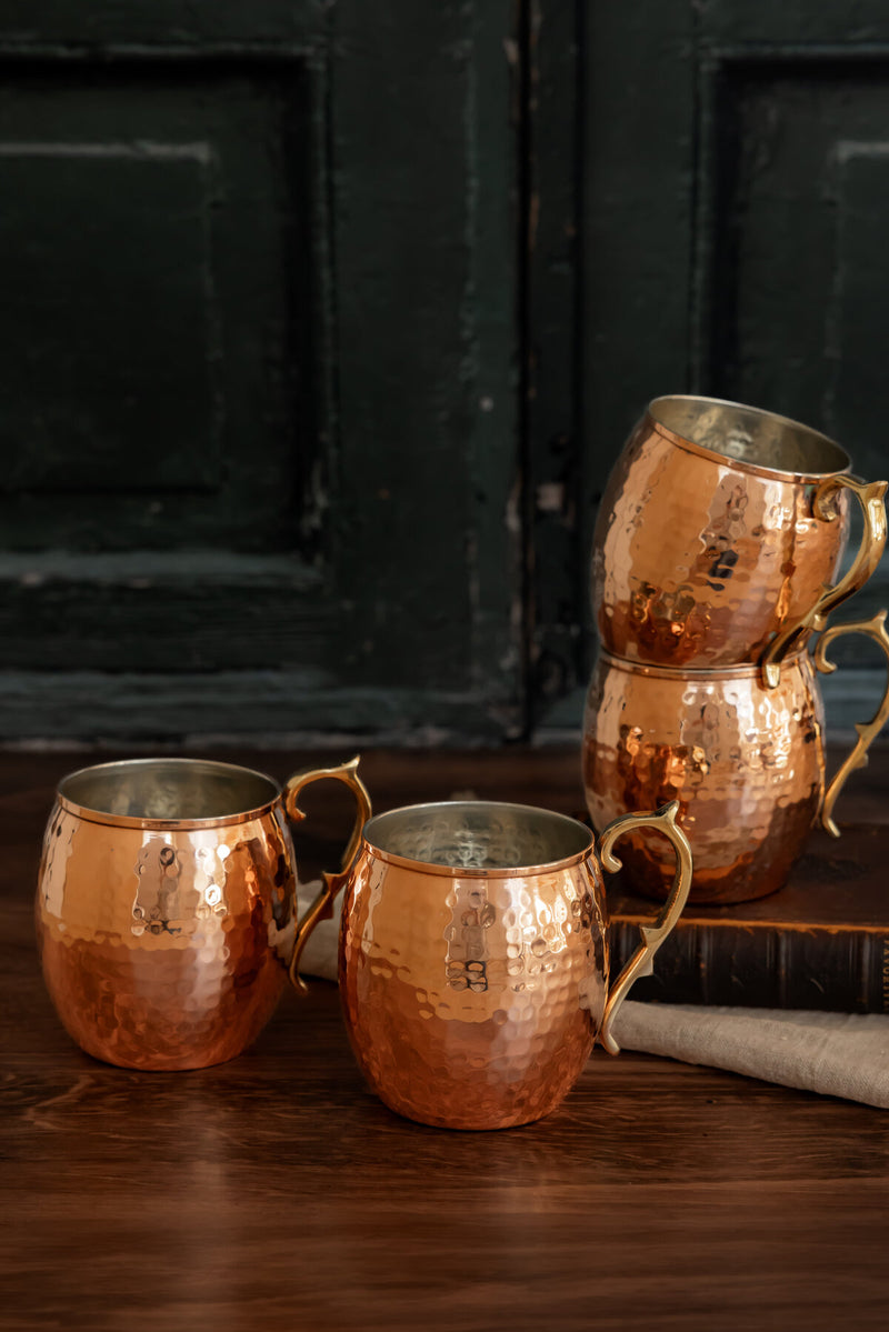 Coppermill Kitchen | Vintage Inspired Moscow Mule Mugs, hammered-copper set of four with artisanal handles, ideal for enhancing your home bar's elegance and functionality.